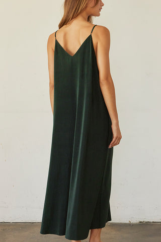 A model wearing a hunter green pleated velvet midi dress.
