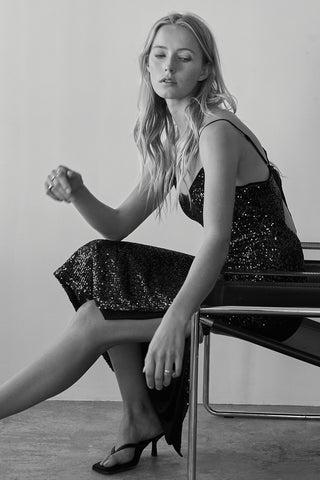 A model wearing an emerald sequins tie back midi dress.
