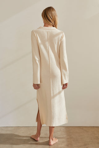 A model wearing a cream textured polo knit midi dress.
