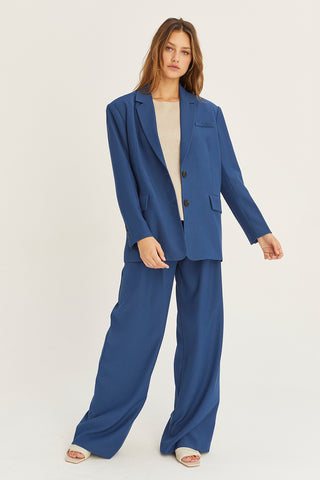 A woman wearing a blue oversized single breasted blazer.