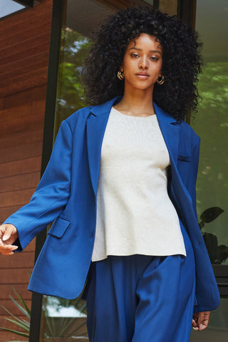A woman wearing a blue oversized single breasted blazer.