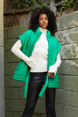 A model wearing a green quilted puffer vest.