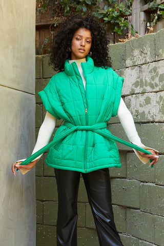 A model wearing a green quilted puffer vest.