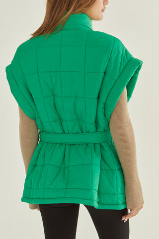 A model wearing a green quilted puffer vest.