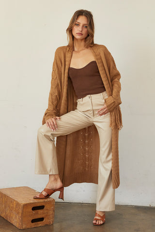 A model wearing a camel fringe duster cardigan.