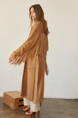 A model wearing a camel fringe duster cardigan.