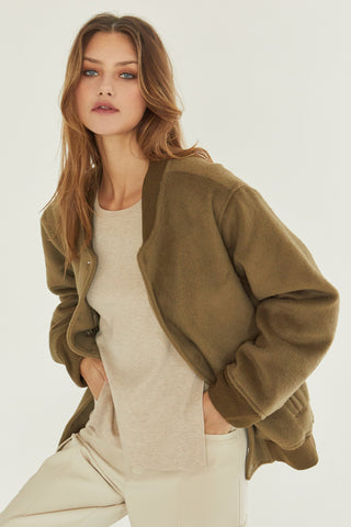 A model wearing an olive brushed vegan wool bomber jacket.