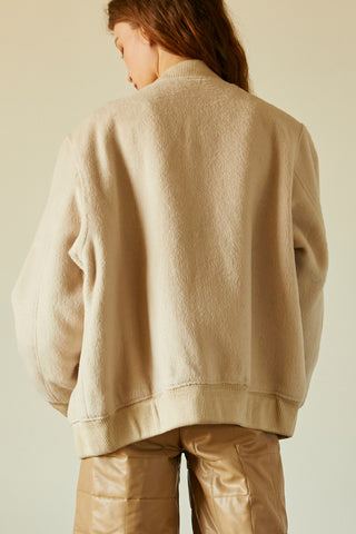 A model wearing a bone brushed vegan wool bomber jacket.