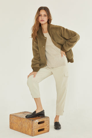 A model wearing an olive brushed vegan wool bomber jacket.