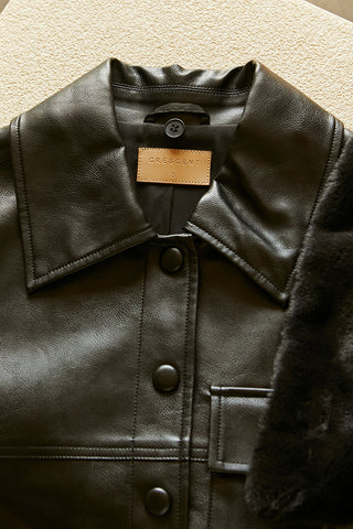 A black vegan leather jacket with detachable fur collar.