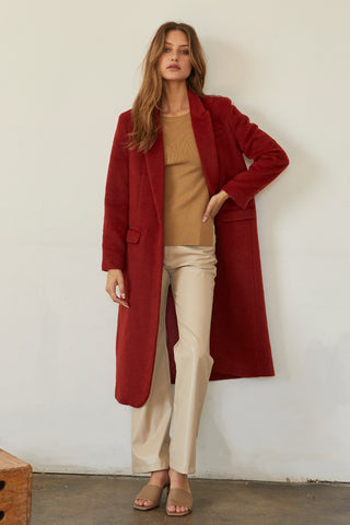 A model wearing a brick brushed vegan wool coat.