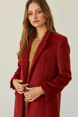 A model wearing a brick brushed vegan wool coat.