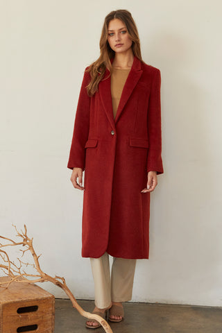 A model wearing a brick brushed vegan wool coat.