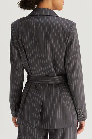 A model wearing a grey pinstriped blazer with waist belt.
