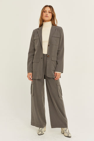 A woman wearing a charcoal Tencel utility blazer with matching pants.