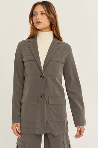 A woman wearing a charcoal Tencel utility blazer with matching pants.