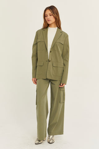 A woman wearing an olive Tencel utility blazer with matching pants.