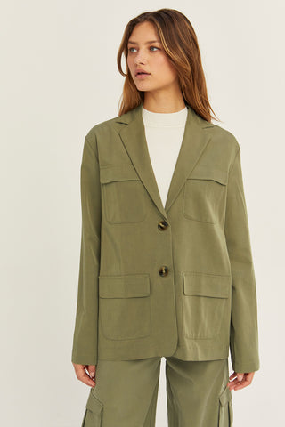 A woman wearing an olive Tencel utility blazer with matching pants.