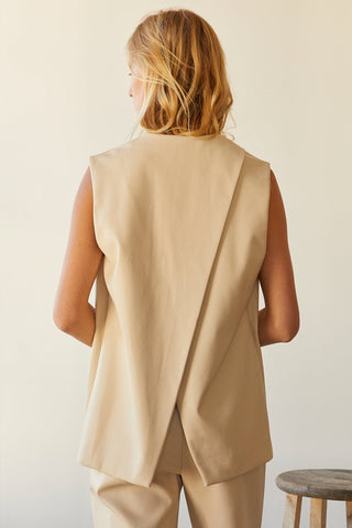 A model wearing a bone vegan leather vest.