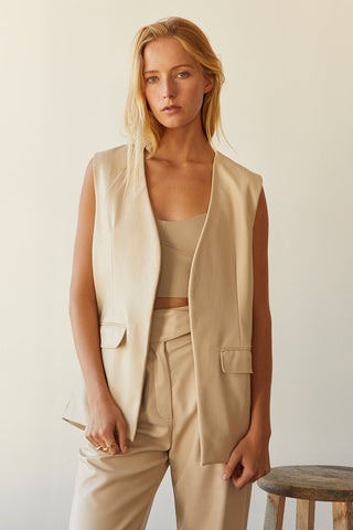 A model wearing a bone vegan leather vest.
