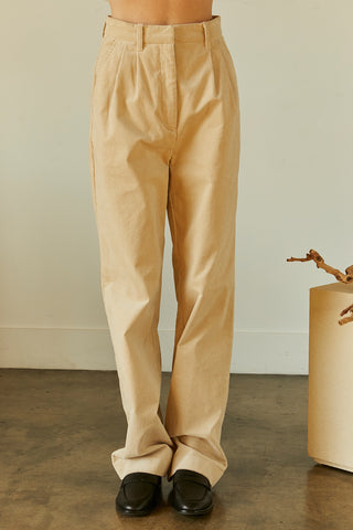 A woman wearing a beige corduroy trousers.