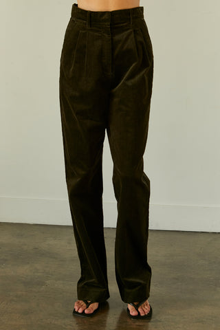 A woman wearing a dark green corduroy trousers.
