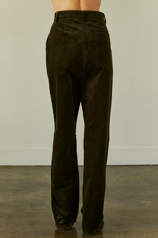 A woman wearing a dark green corduroy trousers.