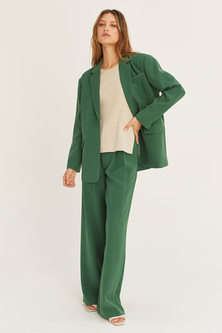 A model wearing a forest wide-leg trousers with matching blazer.