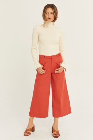A model wearing a brick culotte pants.