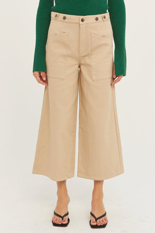 A model wearing a tan culotte pants.
