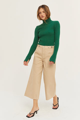 A model wearing a tan culotte pants.