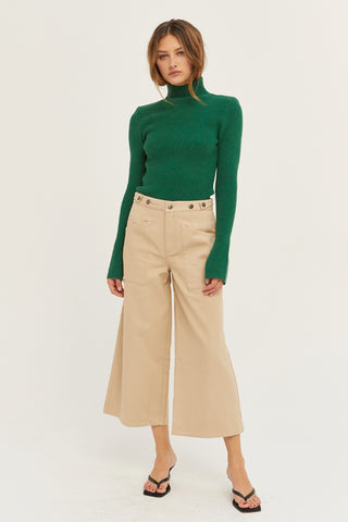 A model wearing a tan culotte pants.