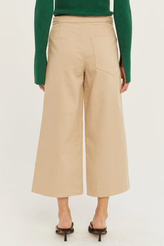 A model wearing a tan culotte pants.