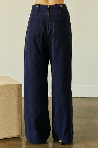 A model wearing a navy corduroy pants.