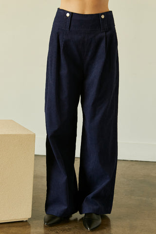 A model wearing a navy corduroy pants.