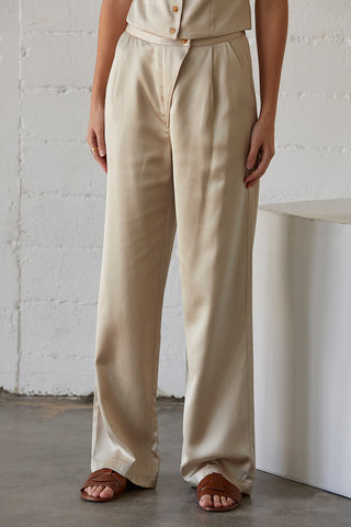 A model wearing a champagne satin pants.