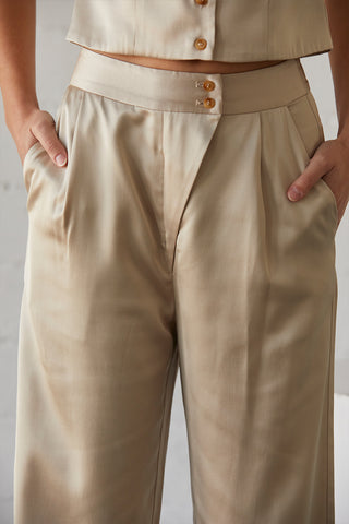 A model wearing a champagne satin pants with matching sleeveless satin top.
