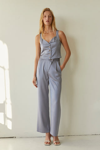 A model wearing a light blue satin pants with matching sleeveless satin top.