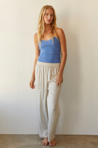 A model wearing a cream satin elastic waist pants.