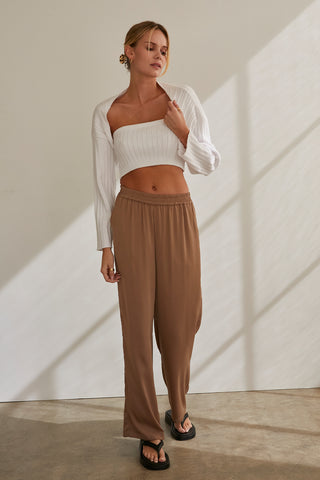 A model wearing a taupe satin elastic waist pants.