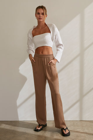 A model wearing a taupe satin elastic waist pants.
