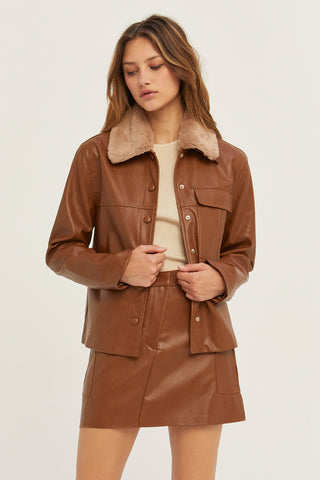 A model wearing a cognac vegan leather utility mini skirt.