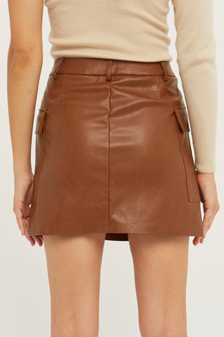 A model wearing a cognac vegan leather utility mini skirt.