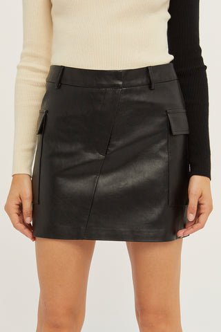 A model wearing a black vegan leather utility mini skirt.