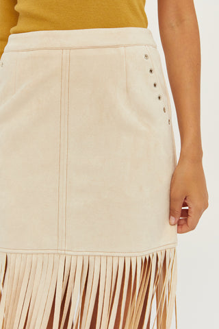 A model wearing a bone fringe suede mini skirt.