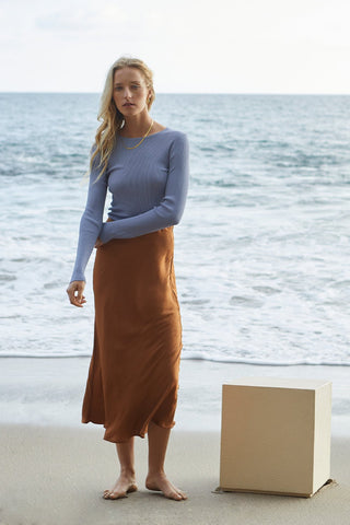 A model wearing a brown satin maxi skirt.