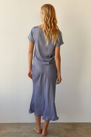 A model wearing a slate blue satin maxi skirt with matching top.