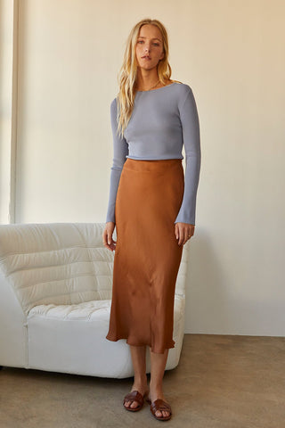 A model wearing a brown satin maxi skirt.