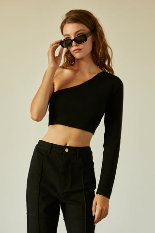 A woman wearing a black one shoulder long sleeve cropped top.