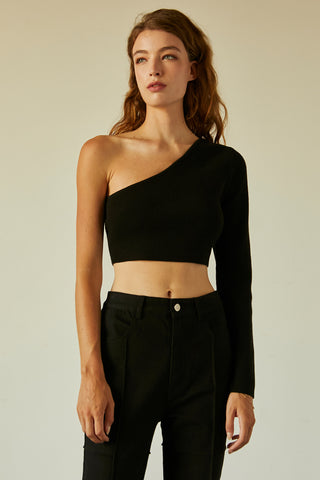 A woman wearing a black one shoulder long sleeve cropped top.
